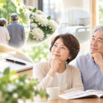明るい室内で将来について考えるシニア夫婦と、散歩する夫婦やノートなどを組み合わせた、元気なうちに葬儀の事前相談を考えるイメージ画像